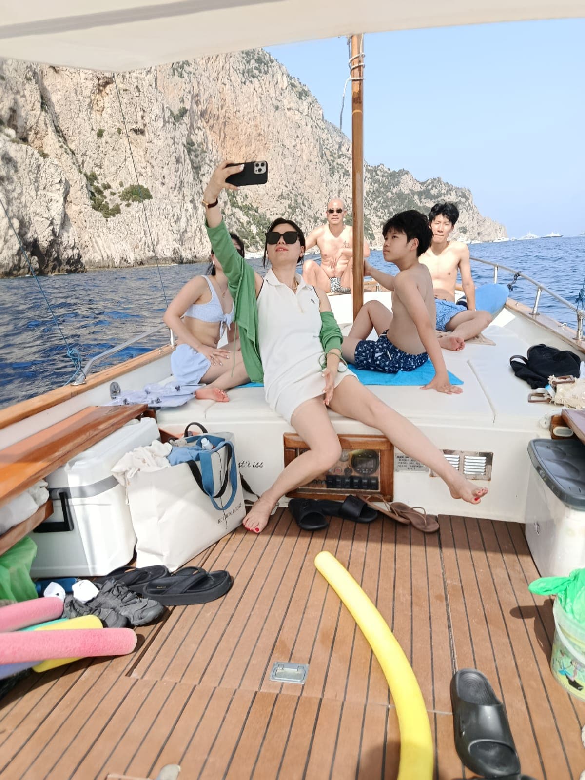 客人在船上自拍,背景是卡普里的岩壁与海面